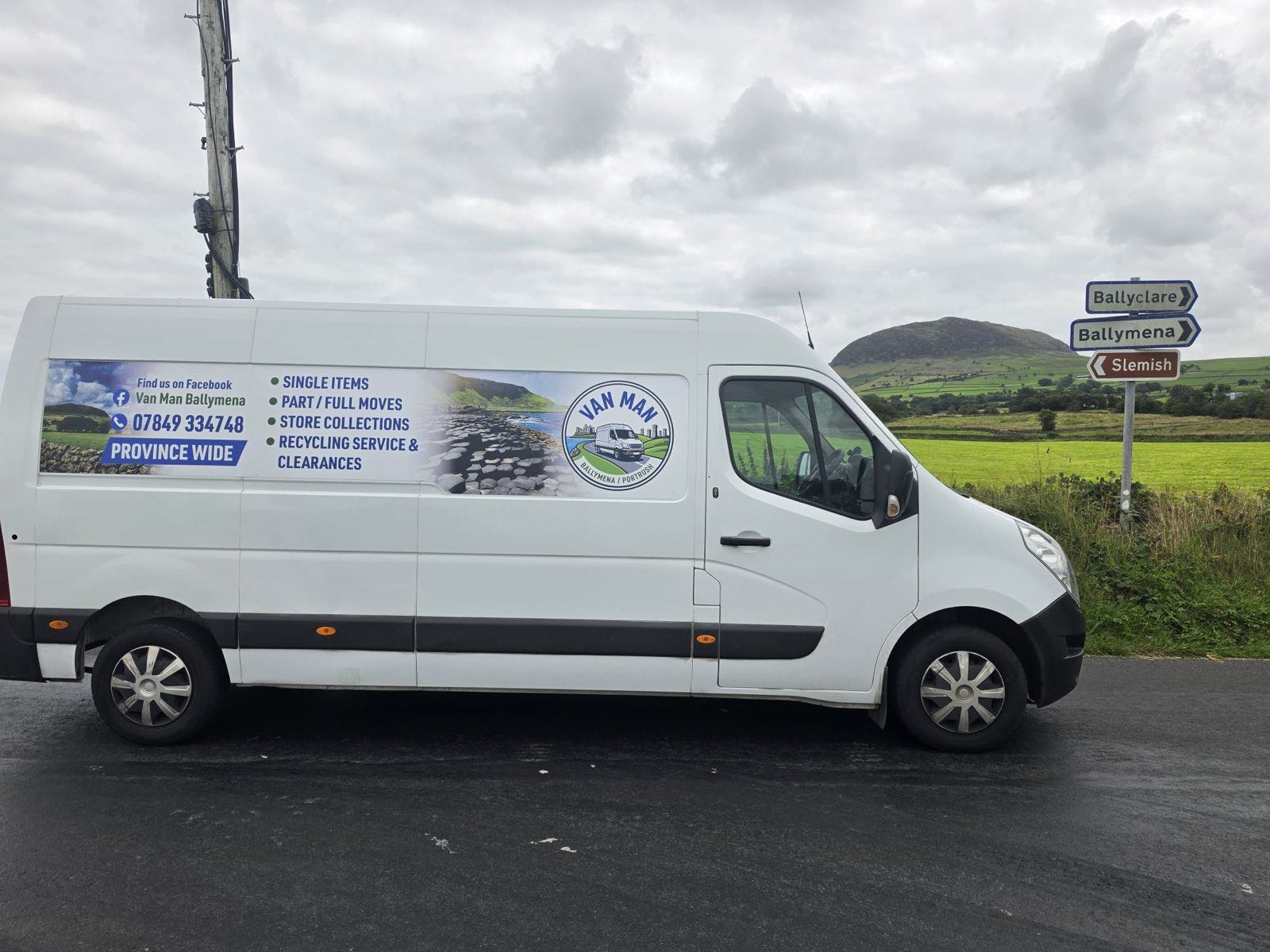 The Van Man Ballymena van beside a Ballyclare, Ballymena and Slemish signpost