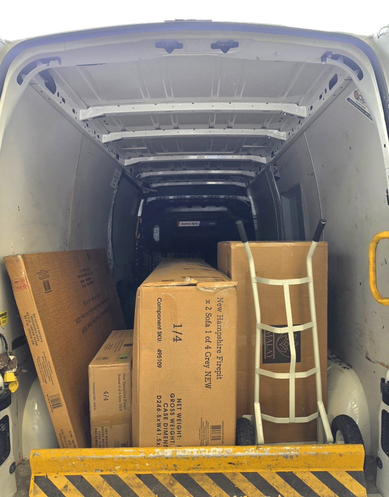 Boxes and a sack truck loaded securely in the back of the van